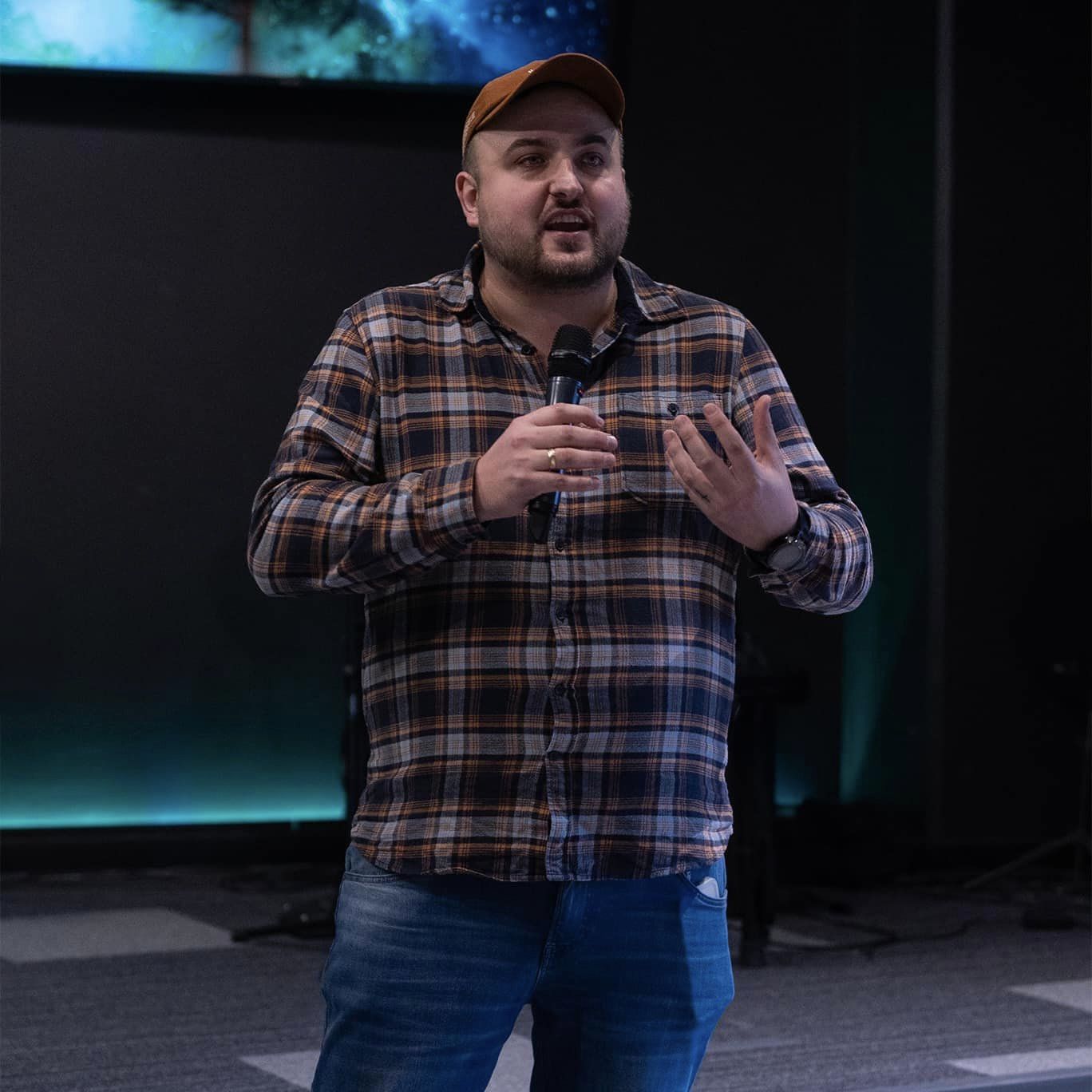 Osoba czytająca książkę w cichej bibliotece, symbolizująca naukę i studium.